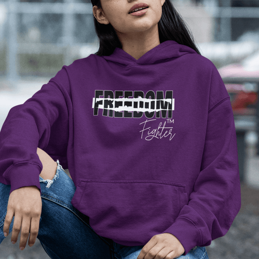 Female Model wearing purple hoodie featuring torn “FREEDOM” text and script “Fighter,” motivational streetwear by LostLogicCo Canada