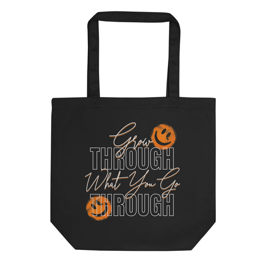 Eco tote bag with “Grow Through What You Go Through” motivational typography design featuring orange smiley faces on black organic cotton by LostLogicCo Canada.