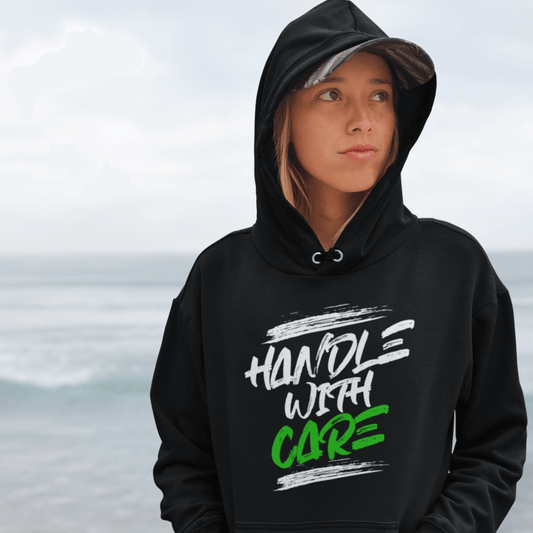 Model wearing black hoodie featuring bold “Handle With Care” brush text design, unisex motivational streetwear by LostLogicCo Canada