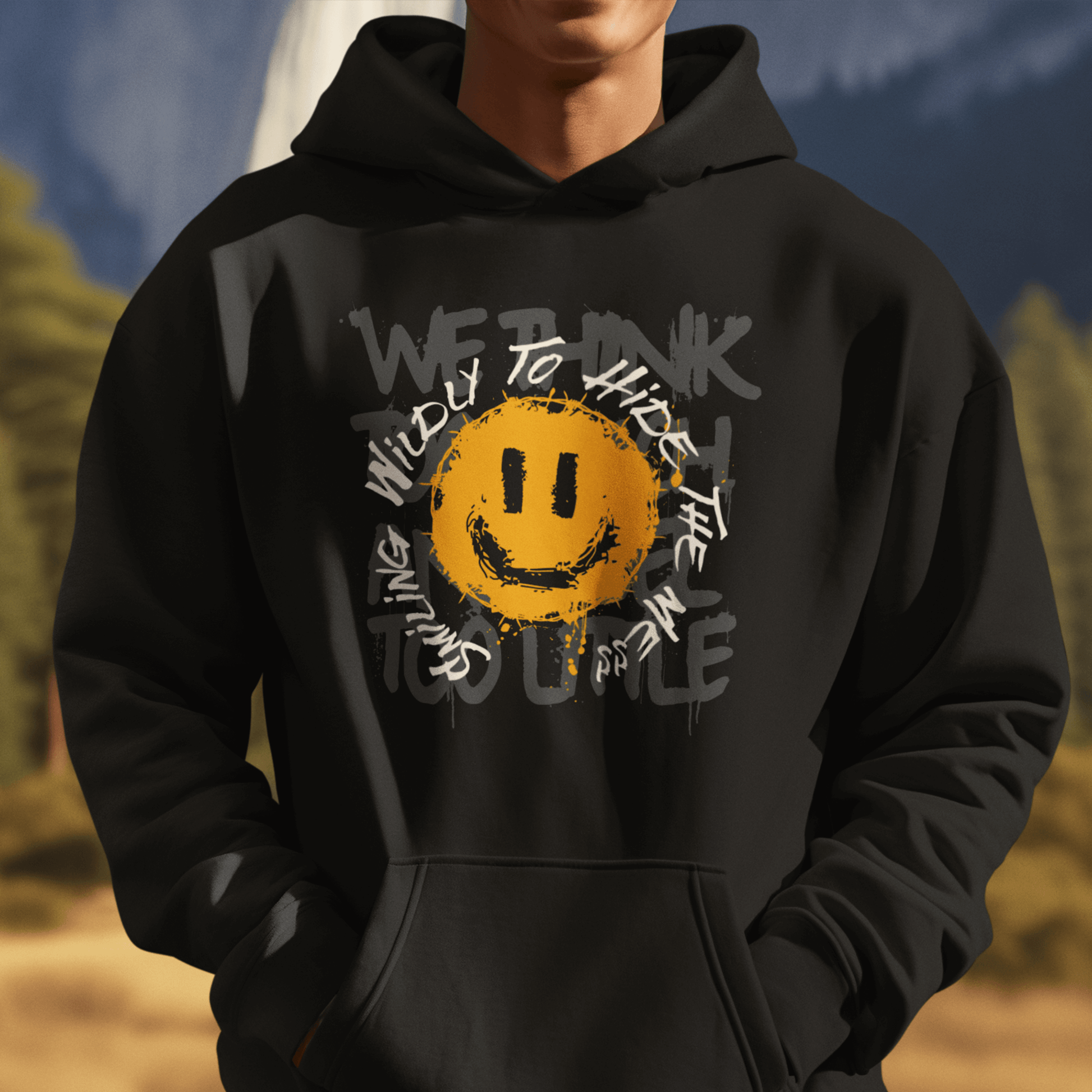 Male Model wearing black hoodie featuring grunge smiley graphic and layered text, expressive streetwear style by LostLogicCo Canada
