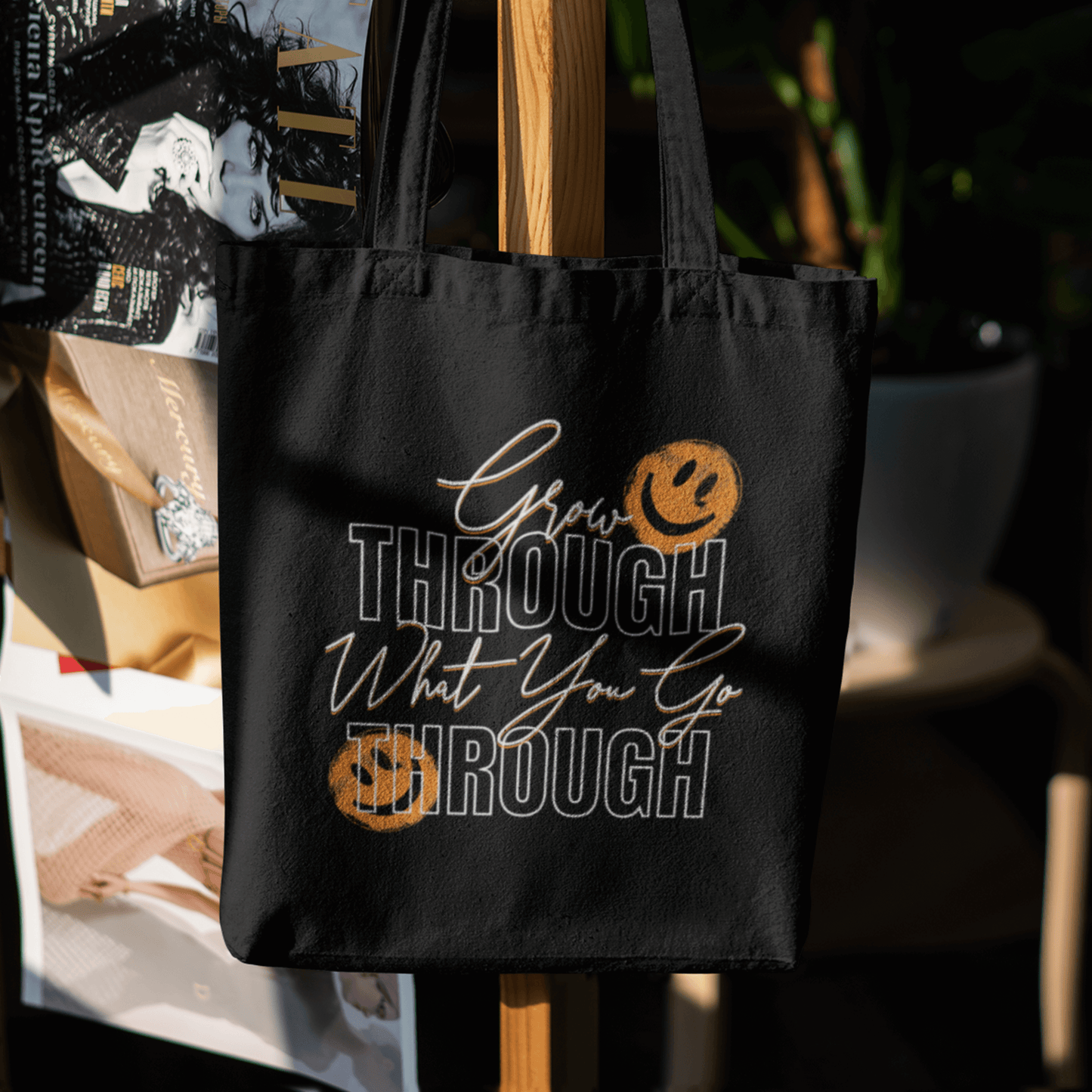 Eco tote bag with “Grow Through What You Go Through” motivational typography design featuring orange smiley faces on black organic cotton by LostLogicCo Canada.