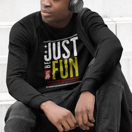 Model wearing black crewneck sweatshirt featuring layered “Just Be Fun” motivational text design, unisex streetwear by LostLogicCo Canada
