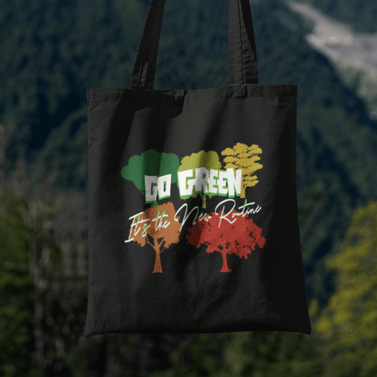 Eco tote bag with “Go Green It’s the New Routine” typography and colorful tree design printed on black organic cotton by LostLogicCo Canada.