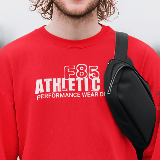 Model wearing “F85 Athletic Co. Performance Wear Division” black unisex sweatshirt with simple white typography design, cozy crewneck by LostLogicCo Canada