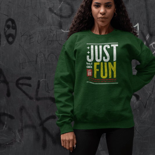 Model wearing green crewneck sweatshirt featuring layered “Just Be Fun” motivational text design, unisex streetwear by LostLogicCo Canada