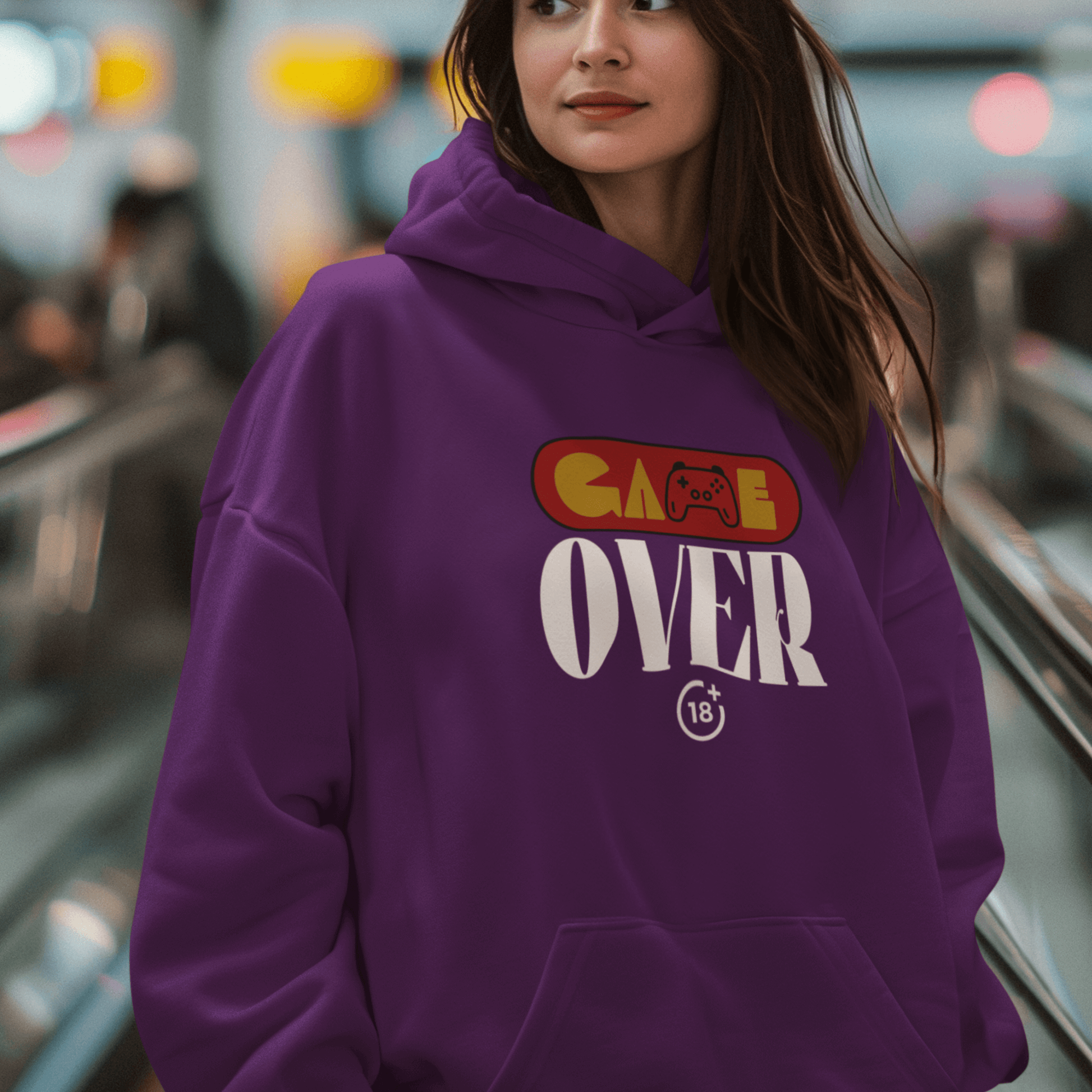 Female Model wearing purple hoodie with retro “Game Over” controller-themed graphic, unisex gamer streetwear by LostLogicCo Canada