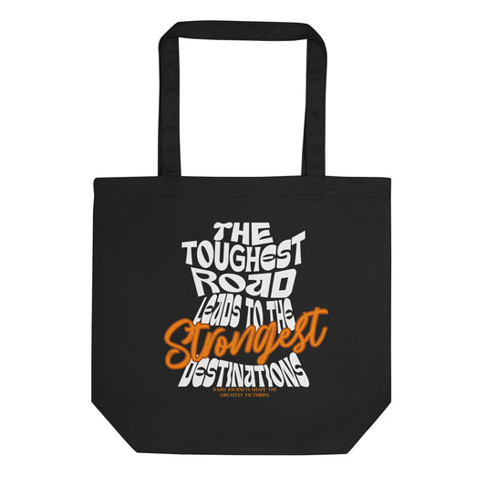 Eco tote bag with “The Toughest Road Leads to the Strongest Destinations” motivational typography design in white and orange on black organic cotton by LostLogicCo Canada.