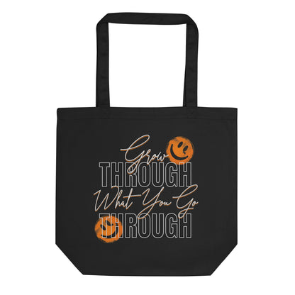 Eco tote bag with “Grow Through What You Go Through” motivational typography design featuring orange smiley faces on black organic cotton by LostLogicCo Canada.
