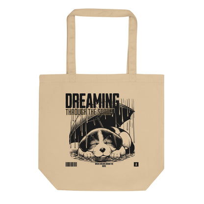 Eco tote bag with “Dreaming Through the Storm” design showing a sleeping puppy under an umbrella, printed on organic cotton by LostLogicCo Canada.